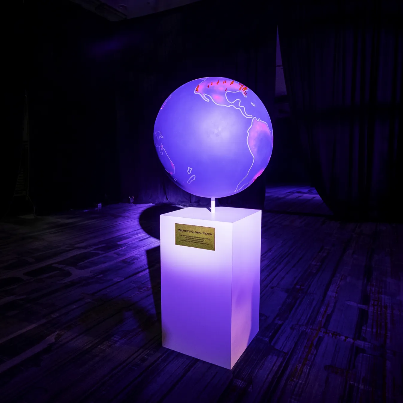 Wilmer's Global Reach, illuminated globe sculpture on custom white pedestal with gold placard, Wilmer Eye Institute Centennial Gala, EventPro scenic fabrication Maryland