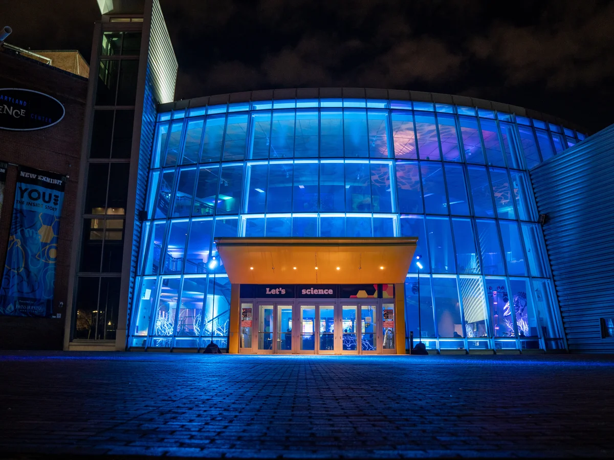 Architectural exterior blue lighting illuminating science center building facade at night by Event Pro