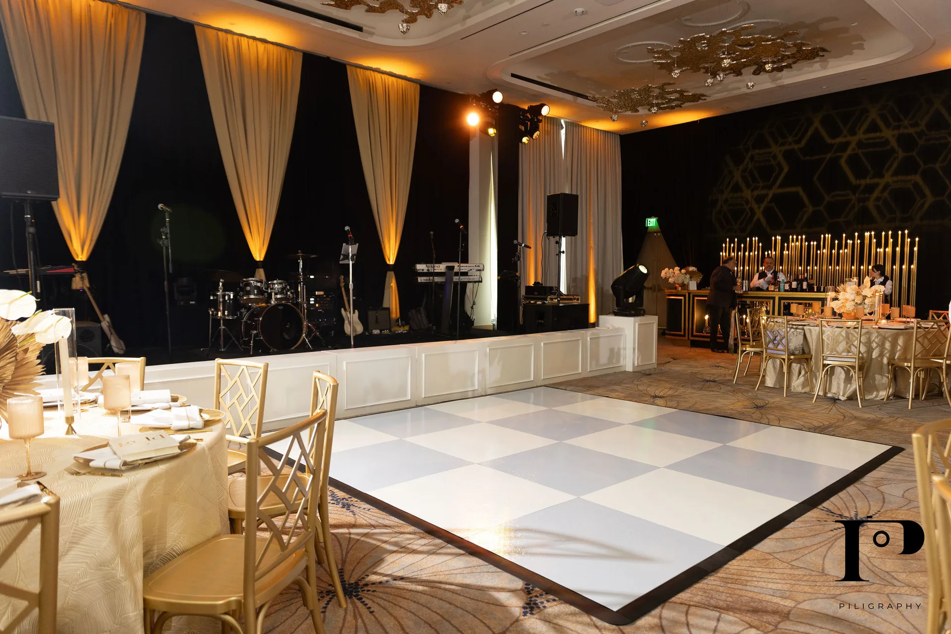 Pier 66 ballroom wide angle, white checkered dance floor, band stage with custom scenic surround, gold and black pipe and drape, EventPro event production Fort Lauderdale