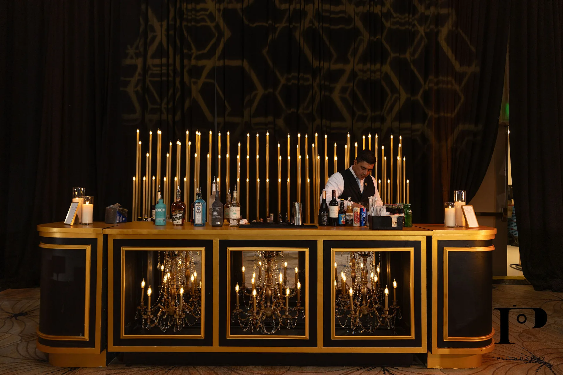 EventPro chandelier bar, black and gold with real chandeliers inside the front face, Solene candle array backdrop, NACE South Florida gala Pier 66 Fort Lauderdale