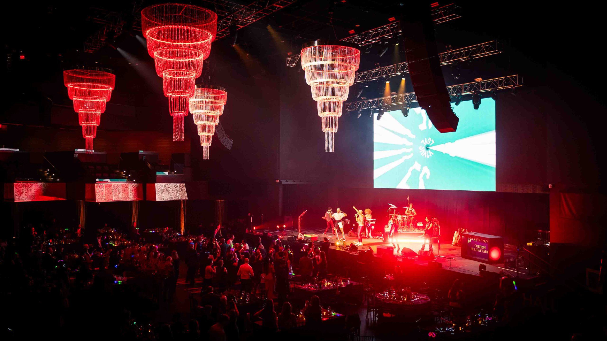 Chandeliers shift to red as the live band takes the stage, concert moment at the Cordish Companies 2024 Holiday Party, EventPro full production, Maryland