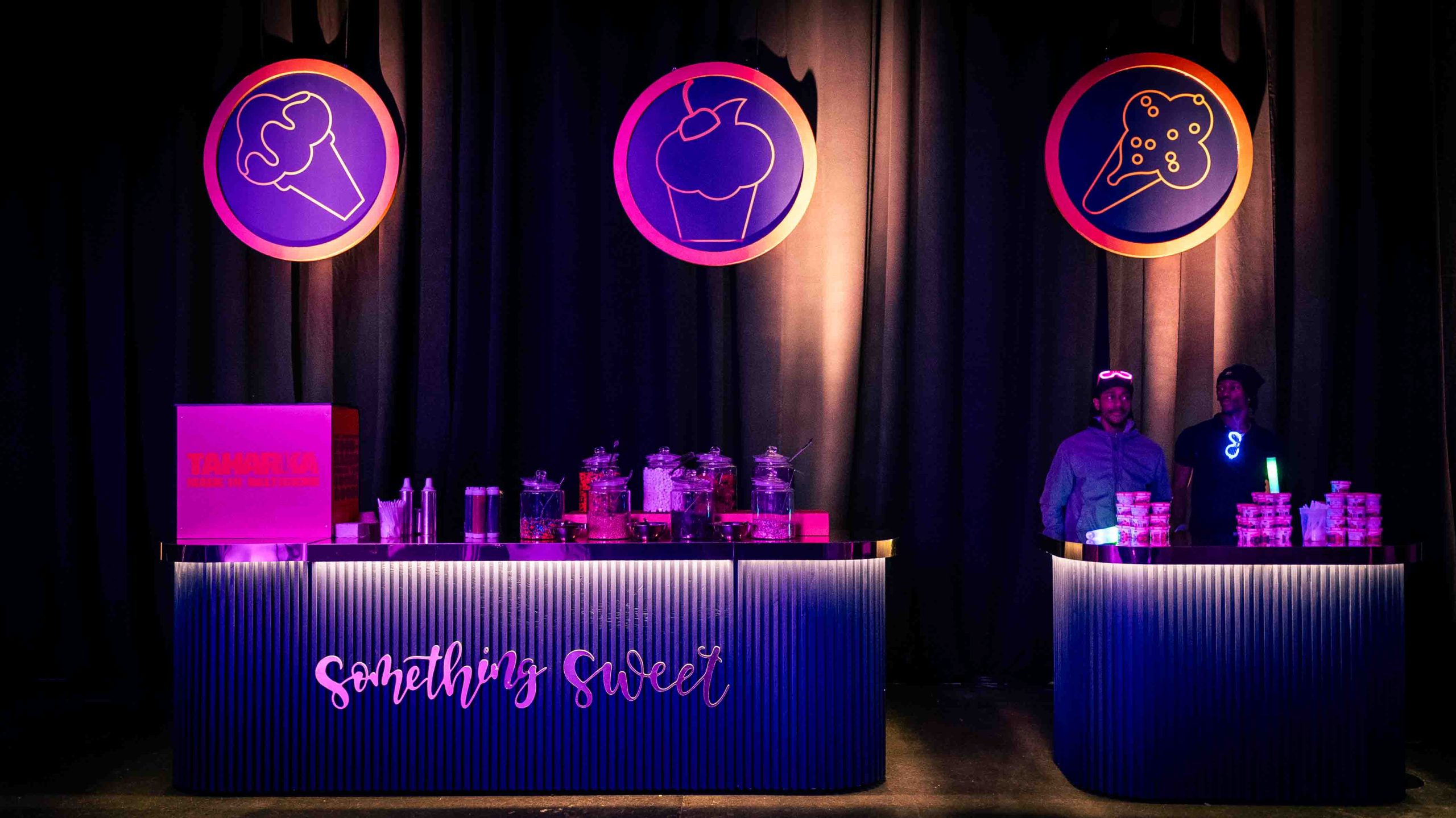 Something Sweet custom fabricated dessert bar with ribbed navy bar front, script lettering, and backlit circular icons, EventPro fabrication for Cordish Companies 2024