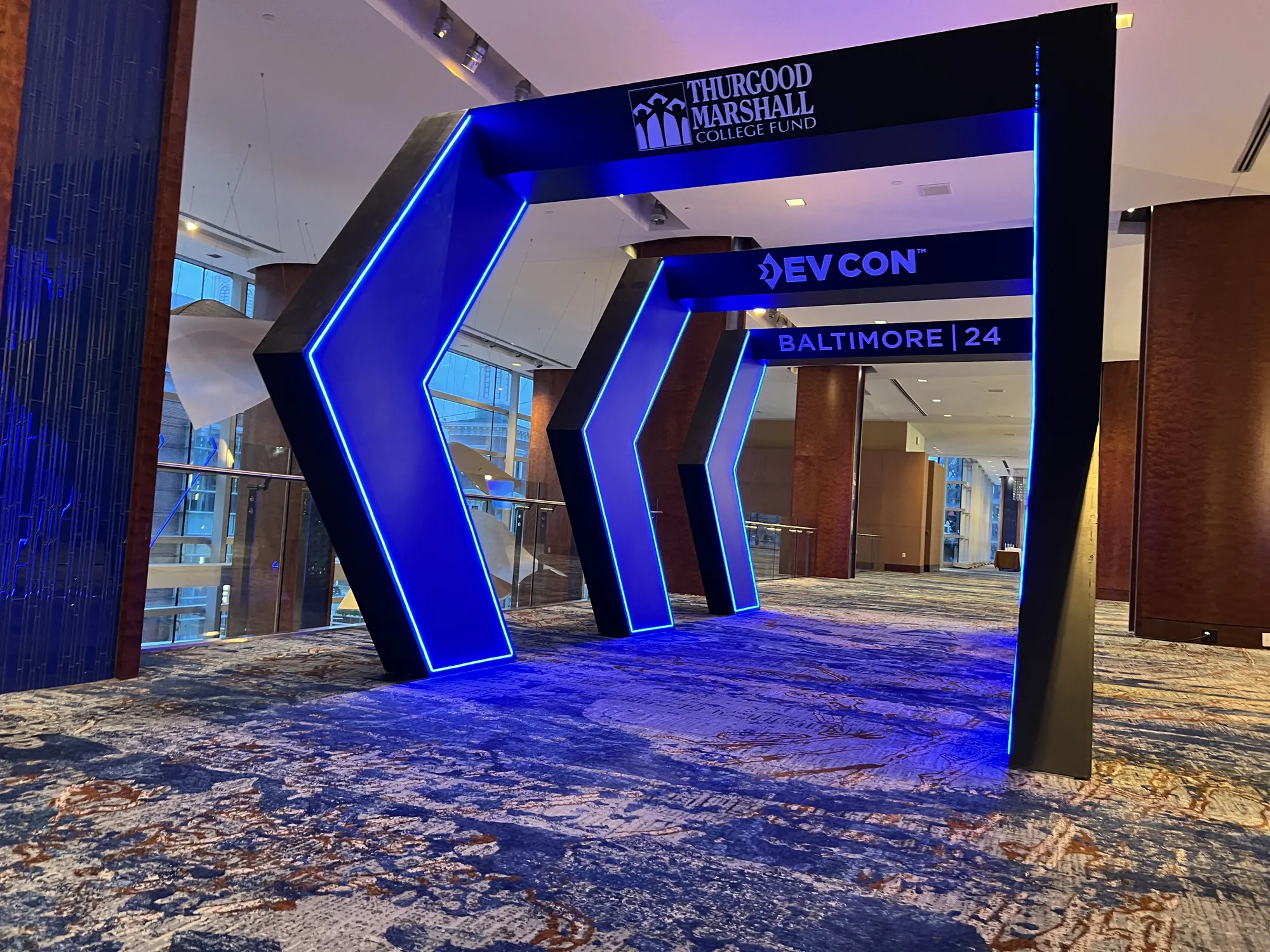 DevCon Baltimore 2024 entrance arch portal head-on with blue LED lighting and event signage, Hilton Baltimore, EventPro