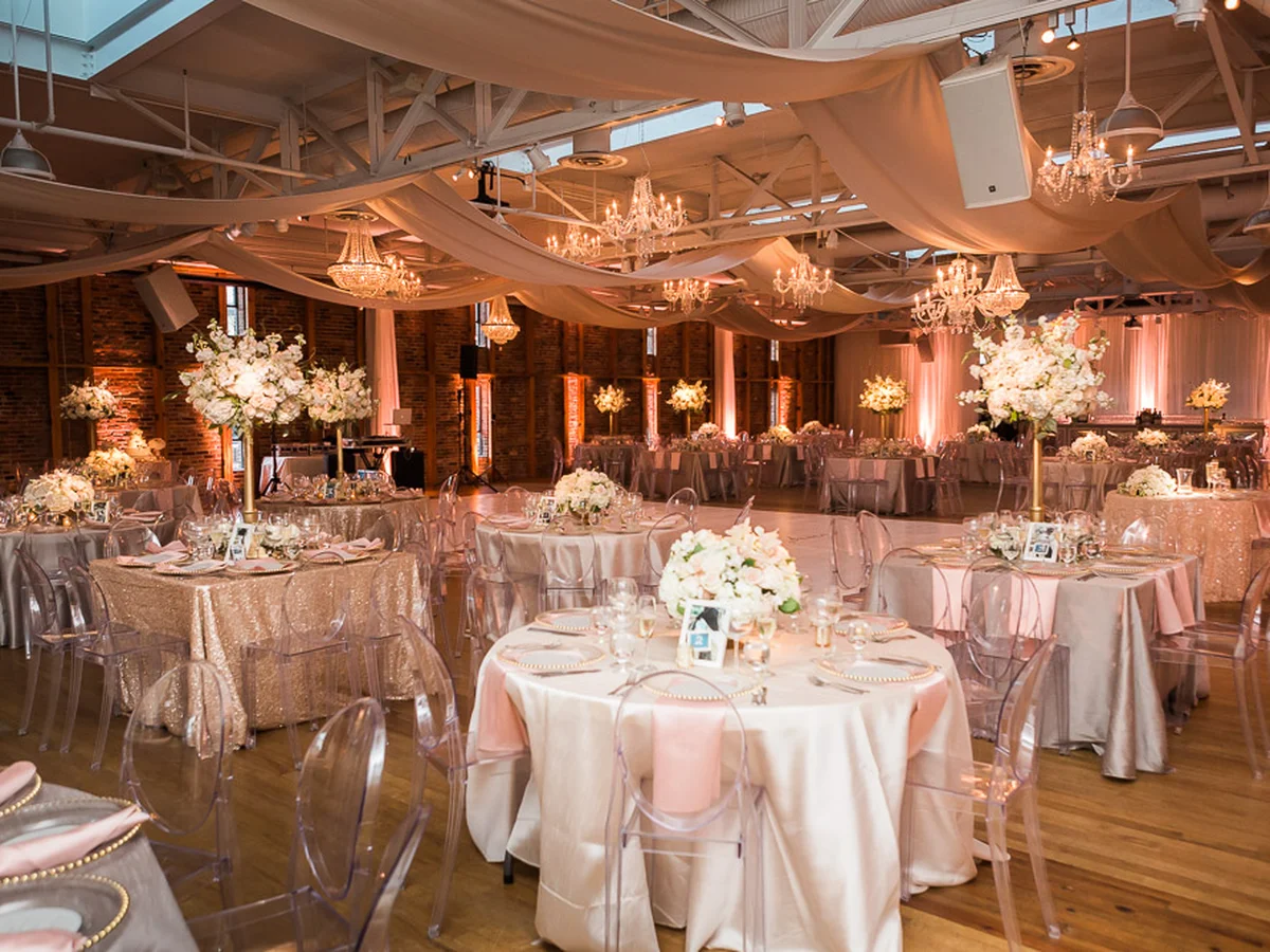 Pink uplighting washing brick walls at elegant wedding reception by Event Pro