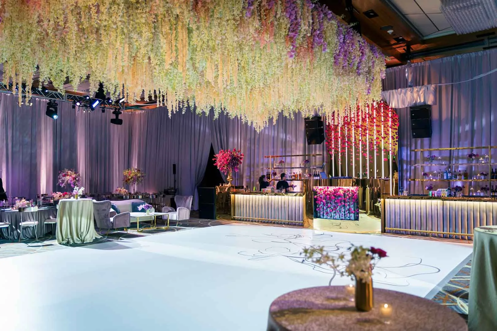 Kam and Kay wedding at Four Seasons Baltimore by wide ballroom overview showing full hanging floral ceiling installation, custom graphic dance floor, bar and floral column backdrop, EventPro production
