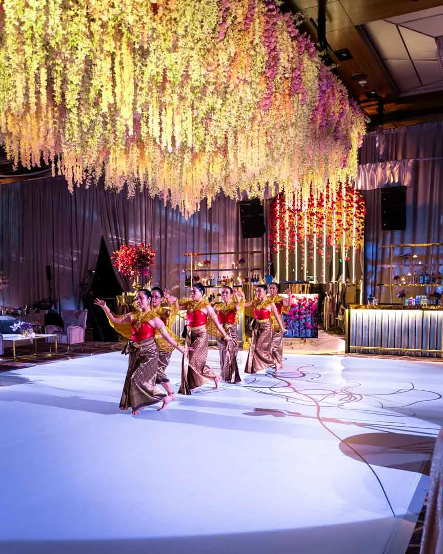 Thai dancers performing in full ballroom at Kam and Kay wedding Four Seasons Baltimore by EventPro hanging floral ceiling, custom dance floor graphic, lit bar installation