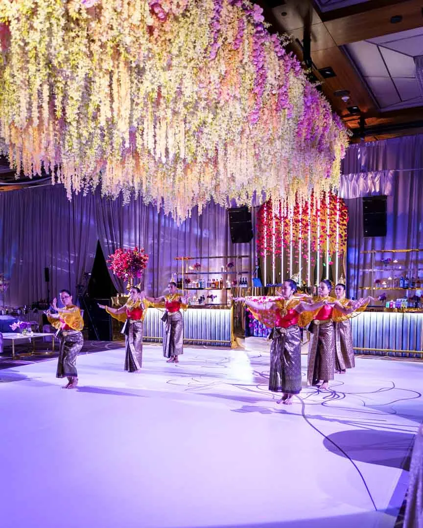 Traditional Thai dancers performing on custom dance floor at Kam and Kay wedding Four Seasons Baltimore by EventPro floral ceiling grid rigging and production above