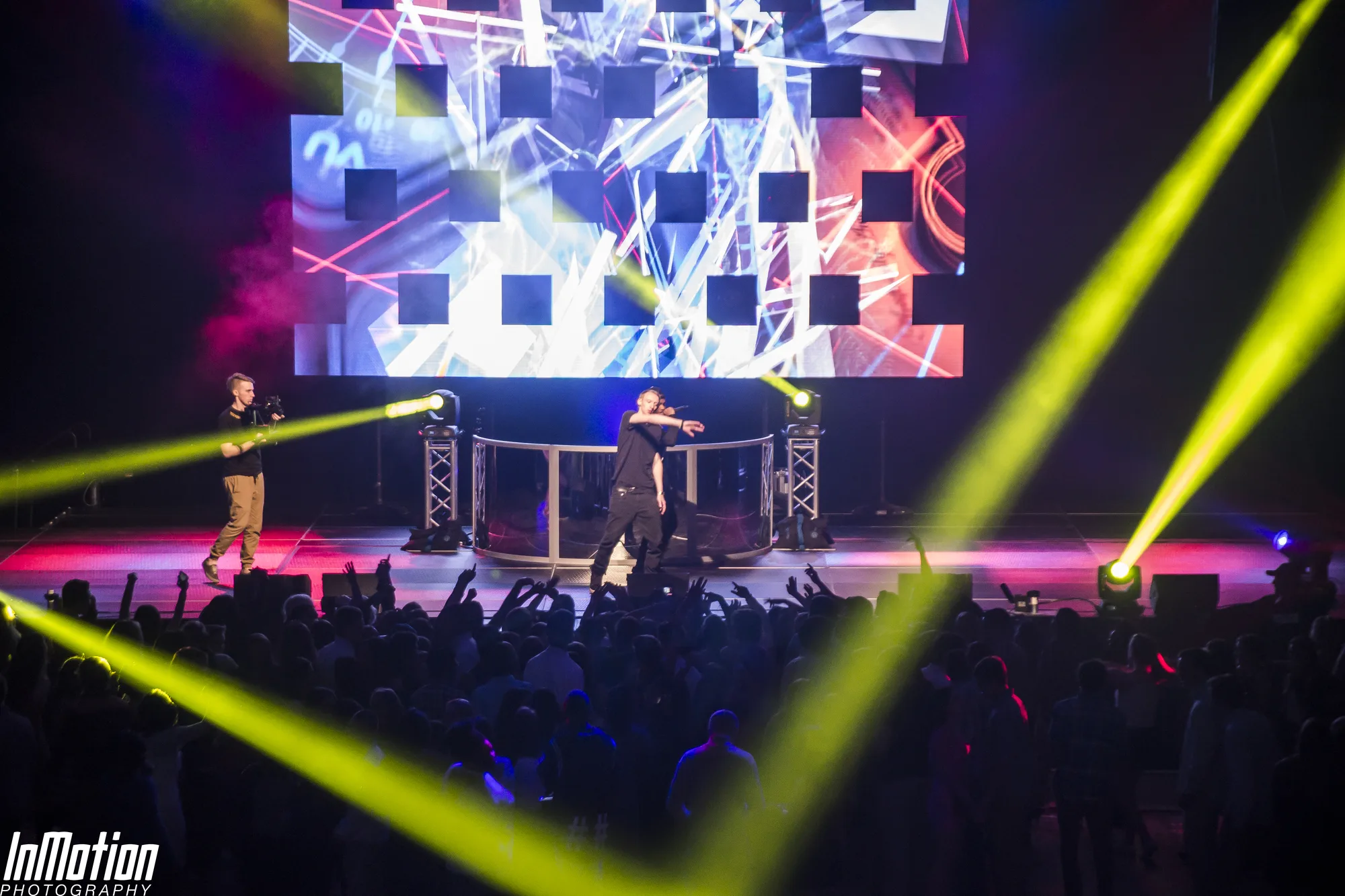 Performers on stage with laser beams crossing the room, LED video wall behind, Lights Out concert APGFCU Arena Maryland, EventPro lighting production