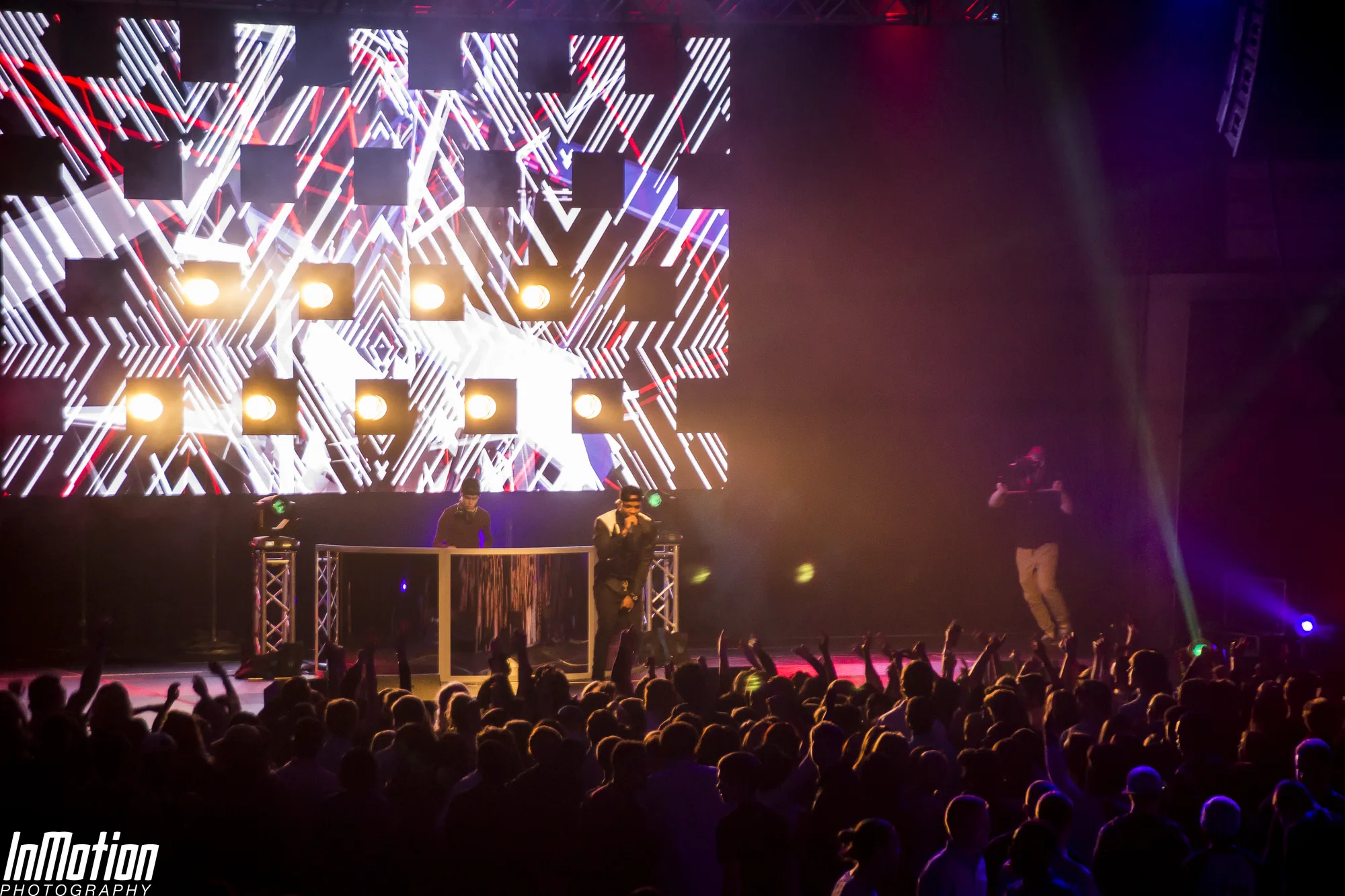 Wide stage view with performers and crowd silhouettes in foreground, LED video wall and moving heads, Lights Out concert APGFCU Arena Maryland, EventPro concert production