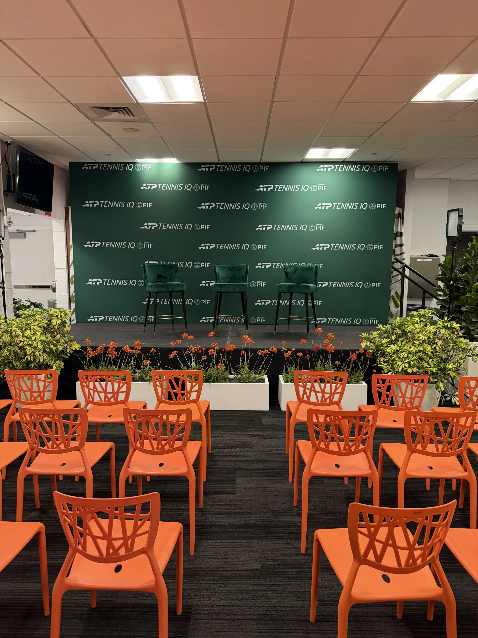 ATP Tennis IQ PIF branded step-and-repeat backdrop with green velvet barstools on raised stage, EventPro press conference production Miami Open