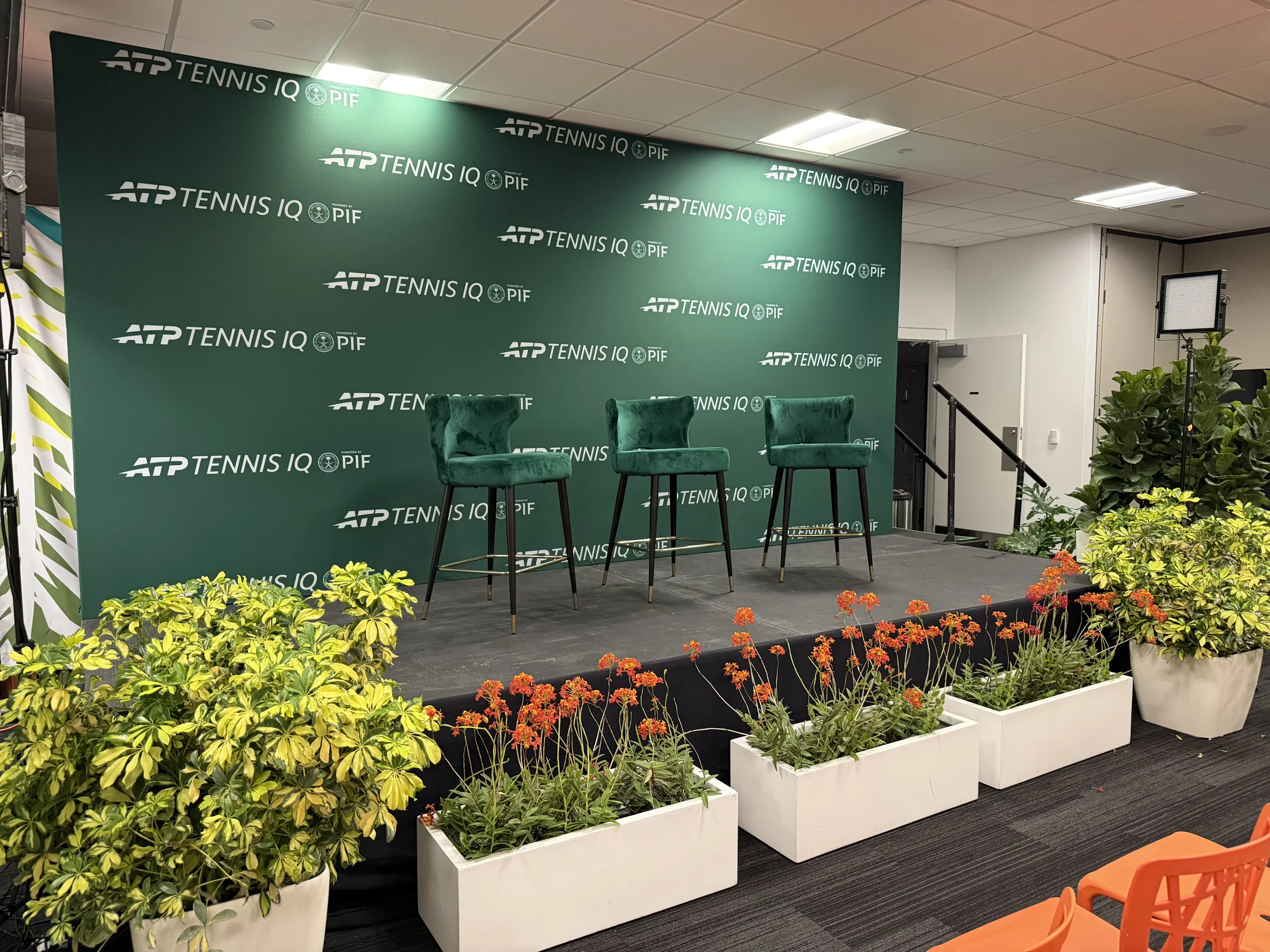 Press conference stage detail, velvet barstools, white planter florals, and PIF branded backdrop, EventPro Miami Open 2026