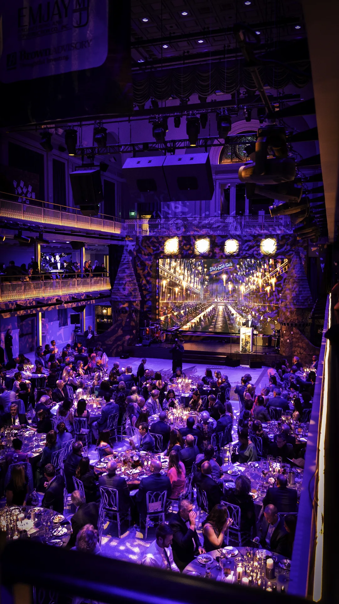 Full crowd at the Mt. Washington Pediatric Hospital Storybook Gala, Hogwarts great hall with floating candles on the LED screen, castle stage set, wide room view, EventPro
