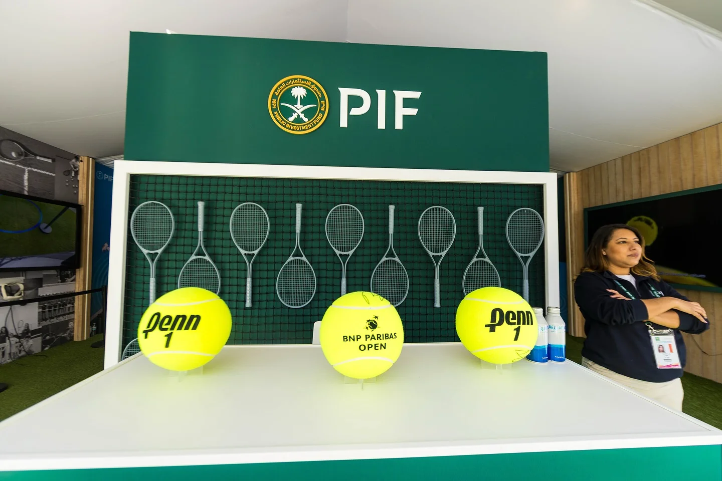 Custom PIF racket display wall with net backing and oversized Penn tennis balls on fabricated counter, BNP Paribas Open pavilion, EventPro