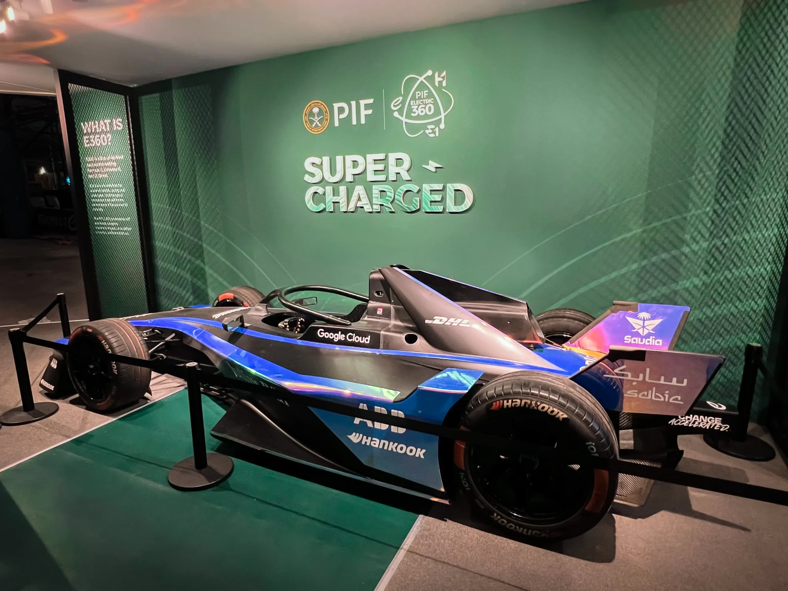Formula E car displayed in front of PIF branded wall inside Super Charged pavilion, Miami Formula ePrix 2025, EventPro