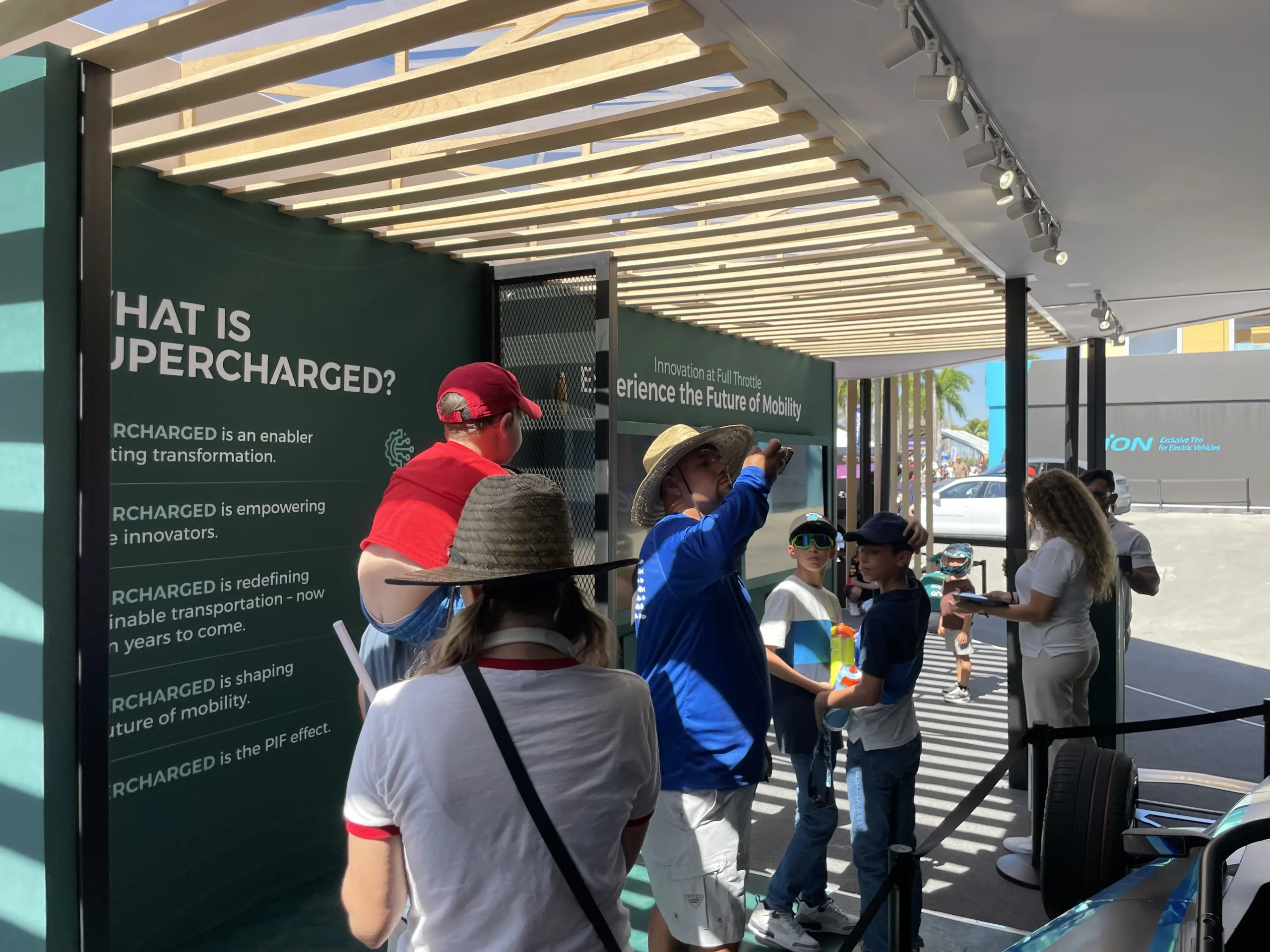Visitors engaging with PIF Super Charged branded signage wall interior, Miami Formula ePrix 2025, EventPro