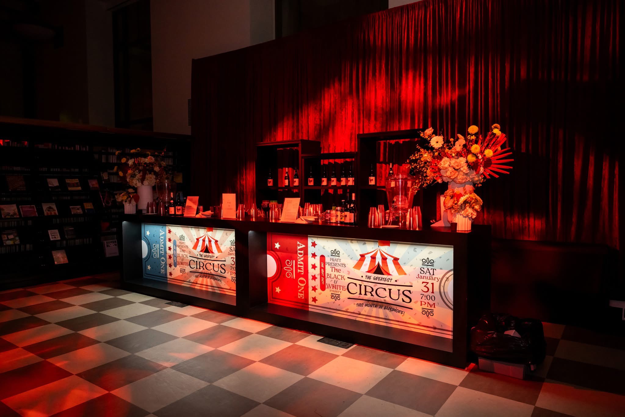 Circus-themed entry bar with ticket booth signage and checkered floor, EventPro environmental design for the Pratt Contemporaries Black and White Party Baltimore