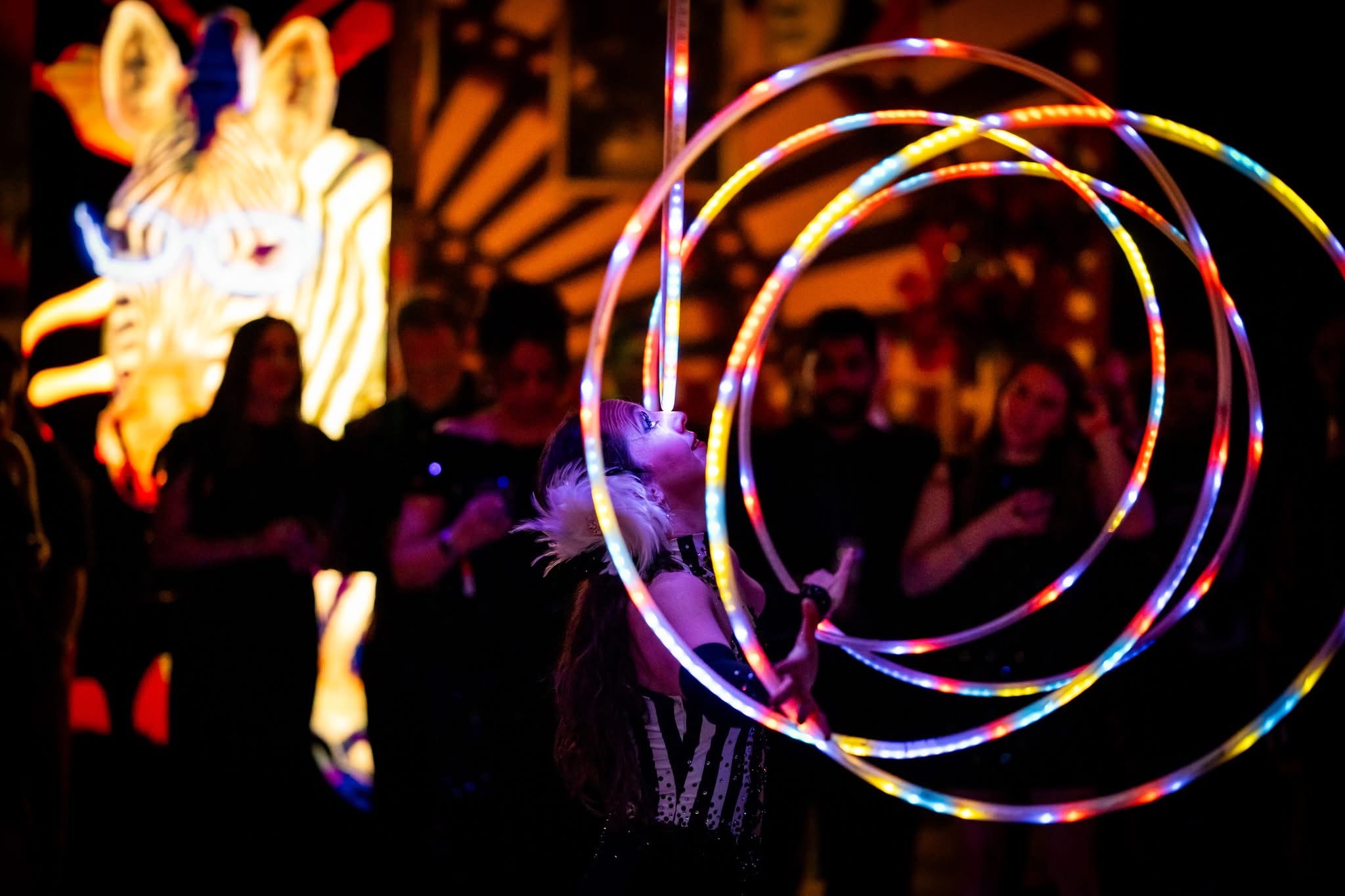 LED hula hoop performer spinning multiple illuminated rings in a zebra costume, Pratt Contemporaries Black and White Party, EventPro Baltimore