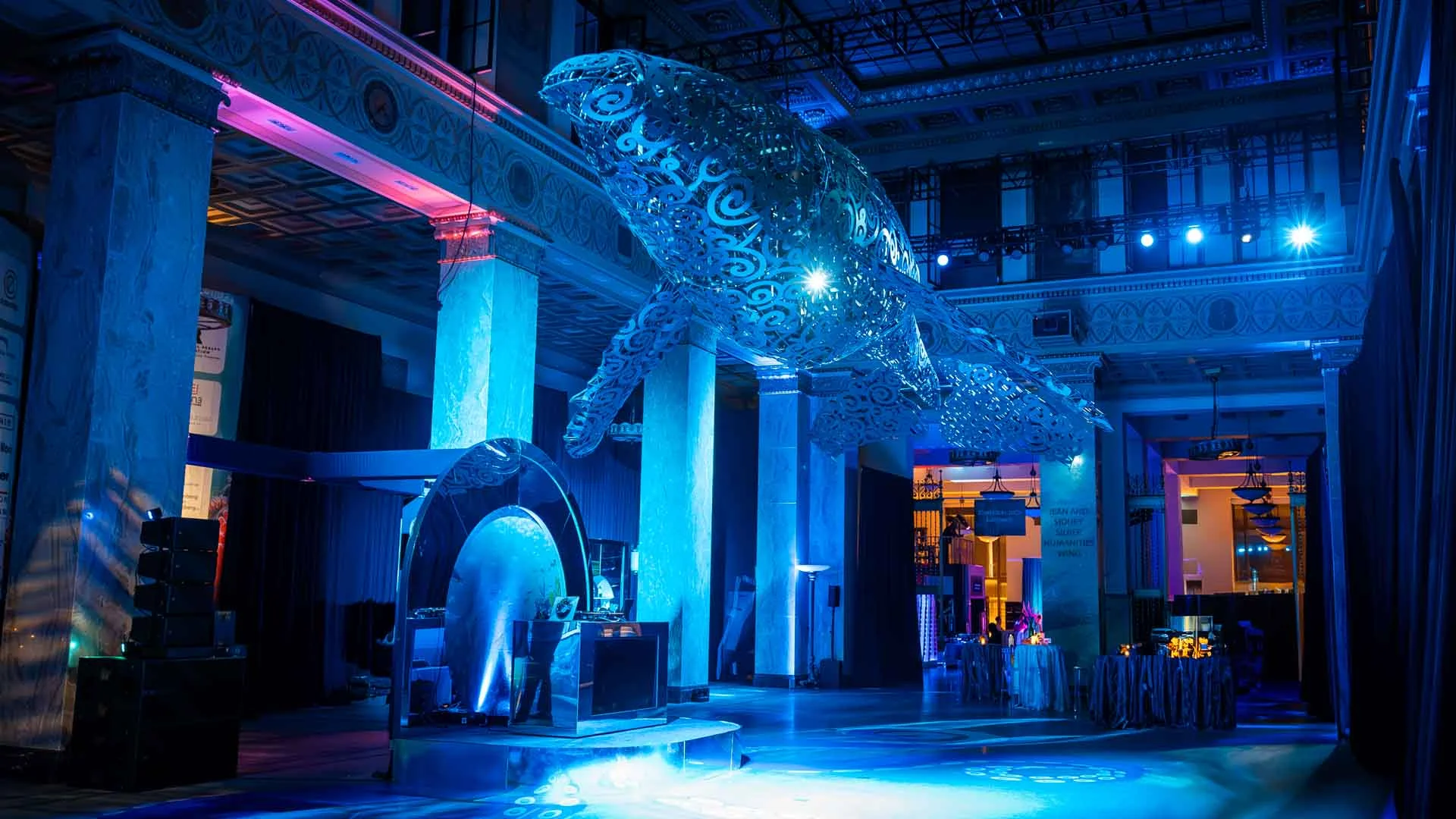 Monumental steel whale sculpture in hall with blue lighting — Enoch Pratt Free Library — EventPro