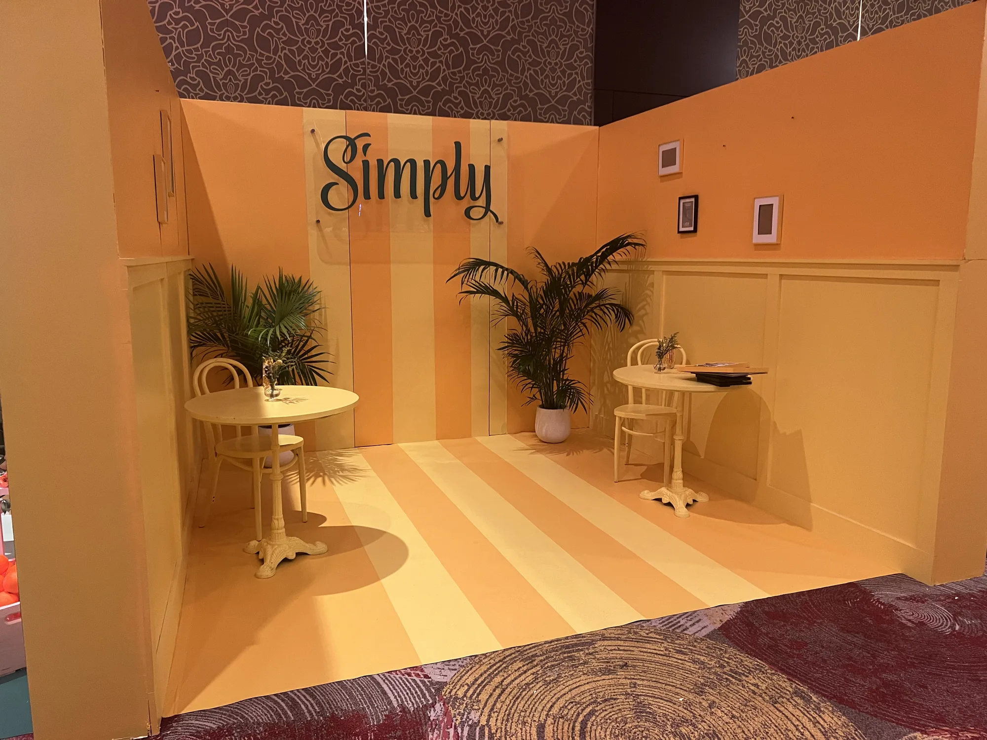 Simply yellow lounge photo room with painted walls, striped floor, wainscoting, cafe tables, and acrylic brand sign, Hard Rock Miami Gardens, EventPro