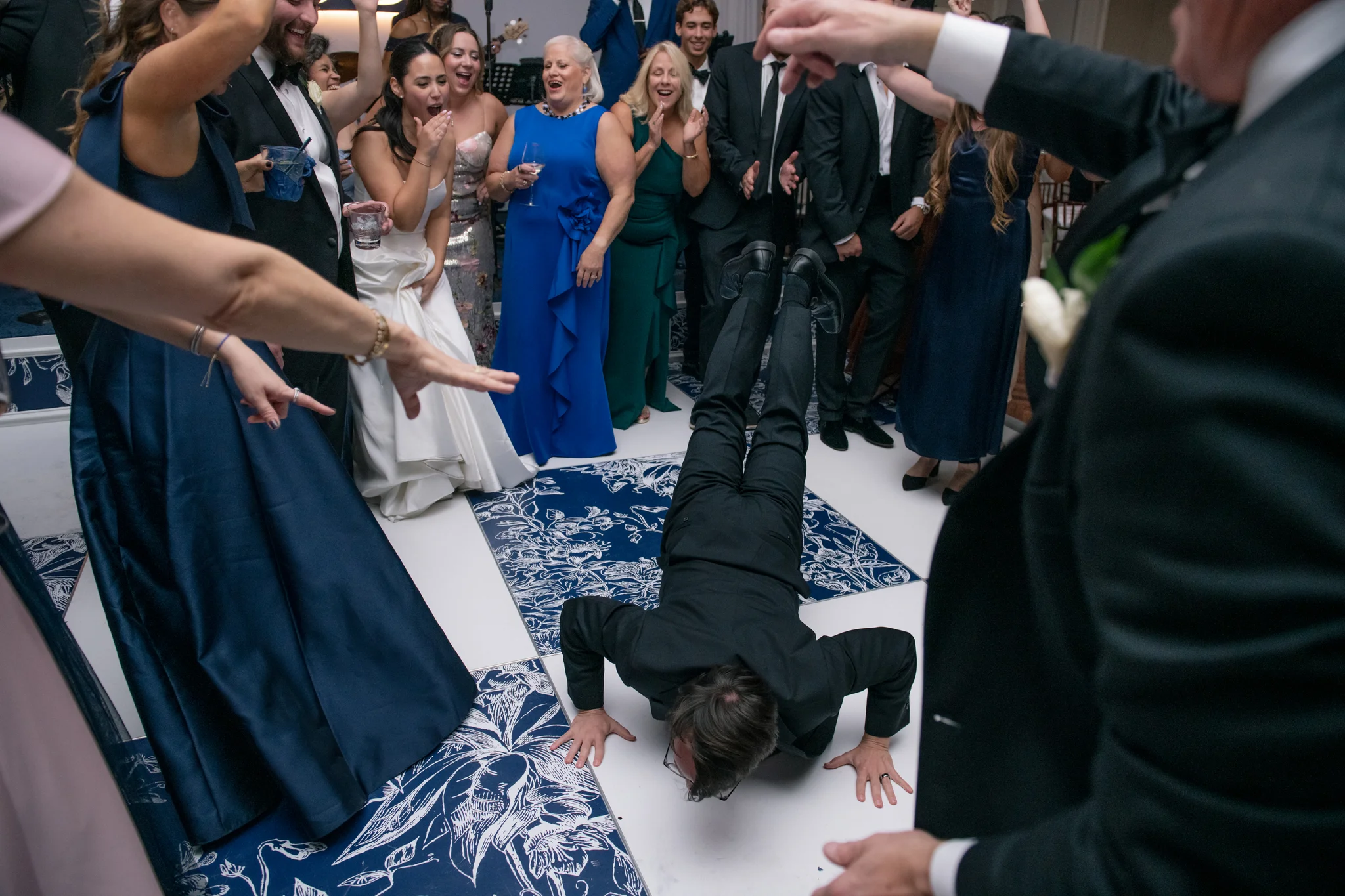 Guests celebrating on EventPro custom dance floor at Brittland Estates Maryland wedding, navy floral printed tiles, S&L LED monogram backdrop glowing behind the crowd