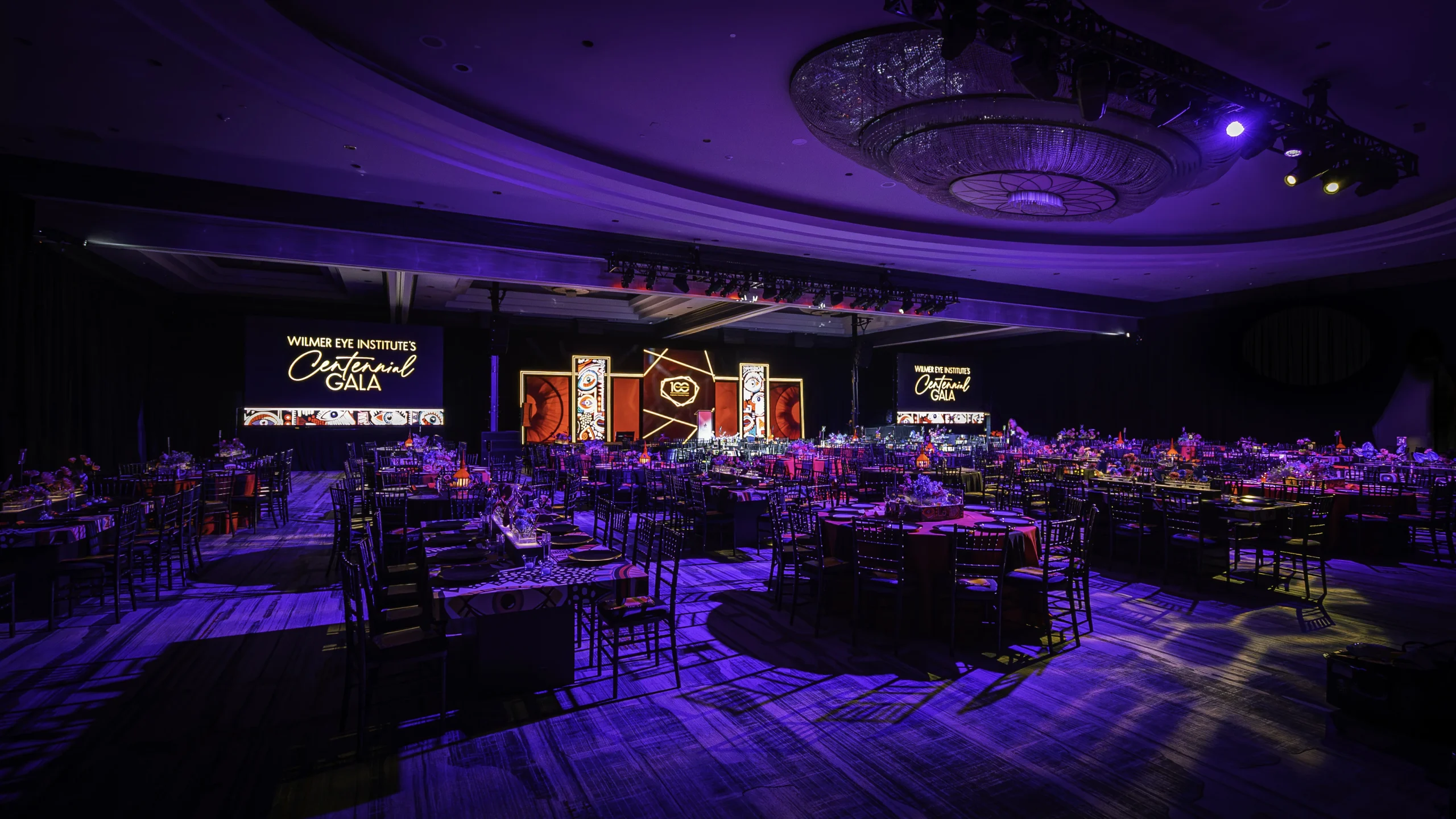 Wilmer Centennial Gala ballroom wide with stage set and purple wash — EventPro event production